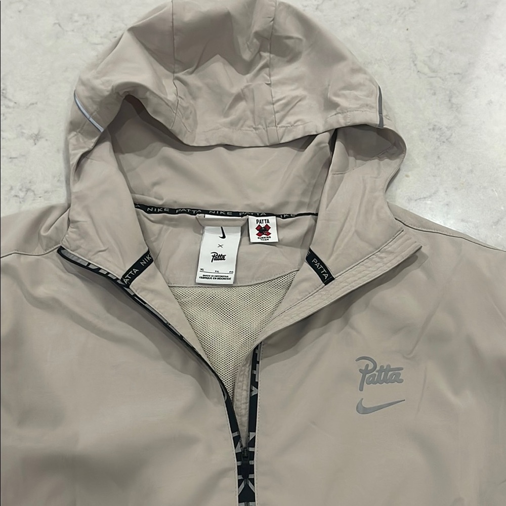 Patta x Nike collab on tan running jacket with hood.  Size XL. Oversized. EUC